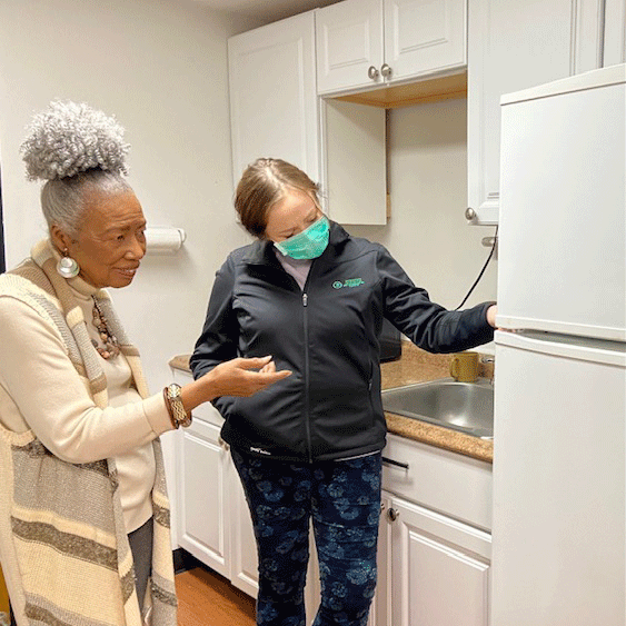 helping older woman with refrigerator